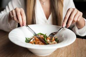 Γυναίκα τρώει φαγητό στο τραπέζι