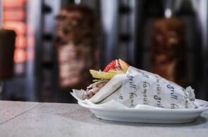 Σουβλάκι σε πάγκο ψητοπωλείου με φόντο τον γύρο