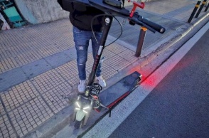 Πατίνι και άτομο πίσω από αυτό που βρίσκεται στο πεζοδρόμιο