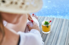 Γυναίκα με ψάθινο καπέλο σε ξαπλώστρα ξενοδοχείου
