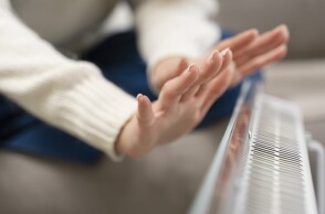 Γυναίκα απλώνει τα χέρια πάνω από το καλοριφέρ