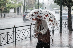 Γυναίκα με ομπρέλα εν μέσω βροχής