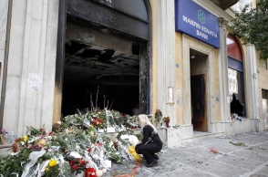 Λουλούδια έξω από τη Marfin λίγες ωρές μετά τον εμπρησμό και την τραγωδία με τους 3 νεκρούς
