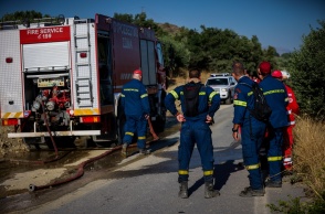 Πυροσβέστες δίπλα από όχημα