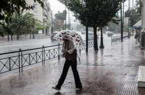 Γυναίκα με ομπρέλα εν μέσω μπουρινιού στο κέντρο της Αθήνας