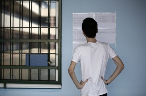 Αγόρι βλέπει τις τοιχοκολλημένες βάσεις των πανελληνίων