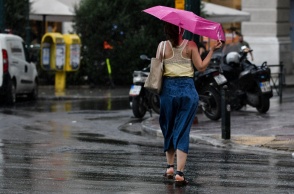 Γυναίκα με ομπρέλα εν μέσω καλοκαιρινού μπουρινιού