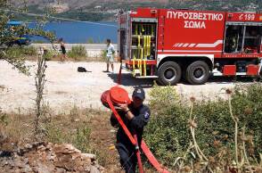 Πυροσβέστης μεταφέρει μάνικα μπροστά από πυροσβεστικό όχημα