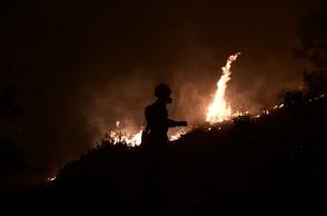 Πυροσβέστης με φόντο τις φλόγες