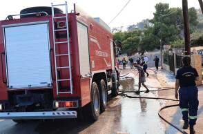 Πυροσβέστες σβήνουν τη φωτιά στη Σαλαμίνα, η οποία απειλεί κατοικίες