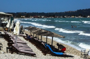 Πολίτες σε παραλία με έντονο κυματισμό και έντονο αέρα