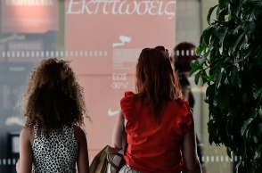 Γυναίκες μπροστά από βιτρίνα με ταμπέλα για θερινές εκπτώσεις 2026