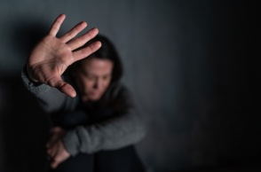 Γυναίκα προτάσσει το χέρι της για να κρύψει το πρόσωπό της