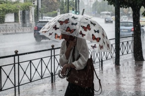 Γυναίκα κρατά ομπρέλα εν μέσω ισχυρής καταιγίδας