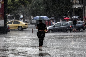 Γυναίκα με ομπρέλα εν μέσω καταιγίδας