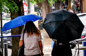 Πολίτες με ομπρέλες εν μέσω καταιγίδας