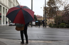Γυναίκα με ομπρέλα στον δρόμο