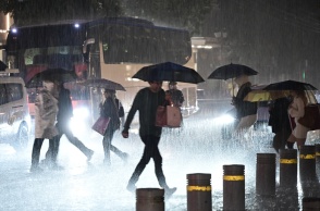 Πολίτες περπατούν στον δρόμο, μπροστά από οχήματα εν μέσω κακοκαιρίας - καταιγίδας