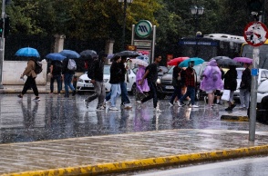 Πολίτες με ομπρέλες εν μέσω βροχής στο Σύνταγμα