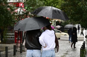 Άτομα με ομπρέλες εν μέσω βροχής