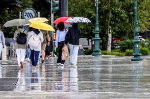Πολίτες με ομπρέλες εν μέσω βροχής στο κέντρο της Αθήνας