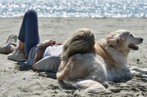 Γυναίκα και σκύλος στην παραλία