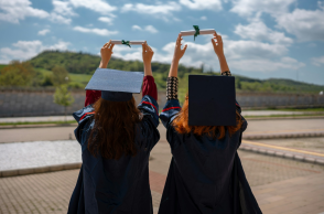 Νεαρές γυναίκες με τίβενο κρατούν στα χέρια τους το πτυχίο τους 