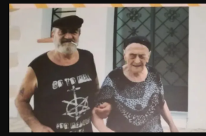 Η γηραιότερη γυναίκα στην Ελλάδα σε παλαιότερη φωτογραφία υποβασταζόμενη από έναν άνδρα με τσιγάρο στα χείλη