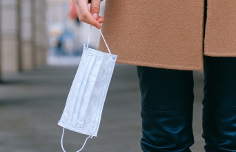 Γυναίκα κρατάει χειρουργική μάσκα