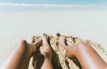 Γυναικεία πόδια στην άμμο παραλίας