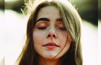 Πορτραίτο νέας κοπέλας με καστανά μαλλιά και κλειστά μάτια