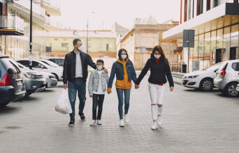 Οικογένεια πιασμένη από το χέρι περπατάει στο δρόμο