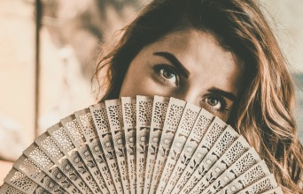 Μια γυναίκα κρατά μια βεντάλια.