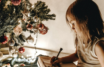 Μικρό κοριτσάκι δίπλα στο χριστουγεννιάτικο δέντρο