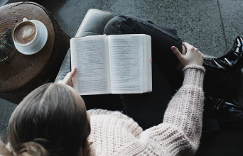 Κοπέλα κάθεται στον καναπέ και διαβάζει βιβλίο