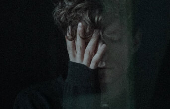 Νέος άντρας που κρύβει το πρόσωπό του