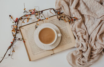 Ανοιχτό βιβλίο με φλιτζάνι καφέ ακουμπισμένο επάνω