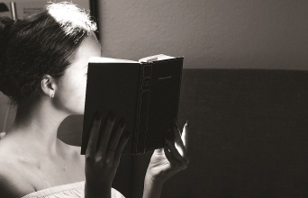 Ένα κορίτσι κρατάει ένα βιβλίο.