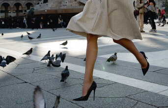 Γυναίκα περπατάει με τακούνια σε πλατεία