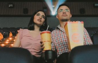 Δύο άτομα βλέπουν μια ταινία στον κινηματογράφο.