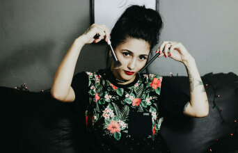 Γυναίκα κρατάει πινέλα δίπλα στα μάγουλά της