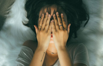 Κοπέλα κρύβει το πρόσωπό της με τα χέρια