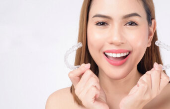 Κοπέλα κρατάει διάφανα μασελάκια