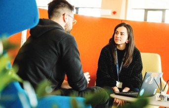 Εργαζόμενοι της Netcompany που συζητούν και δουλεύουν μαζί 