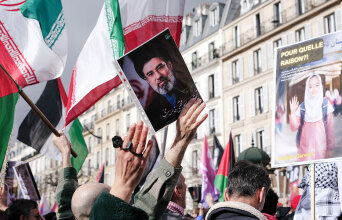 Διαδηλωτές με τη φωτογραφία του Μοτζταμπά Χαμενεΐ και ιρανικές σημαίες στο Παρίσι | 14 Μαρτίου 2026 © Vincent Koebel/NurPhoto via Getty Images