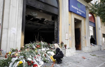 Λουλούδια έξω από τη Marfin λίγες ωρές μετά τον εμπρησμό και την τραγωδία με τους 3 νεκρούς