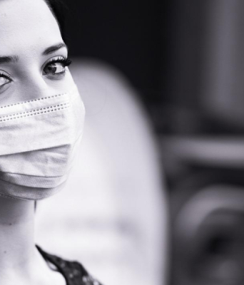 Ασπρόμαυρη φωτογραφία γυναίκας που φοράει χειρουργική μάσκα