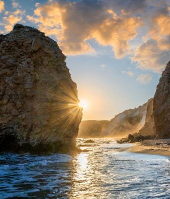 Ηλιοβασίλεμα ανάμεσα σε δύο βράχους σε παραλία της Μήλου