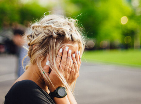 Κοπέλα κρύβει το πρόσωπό της με τα χέρια της