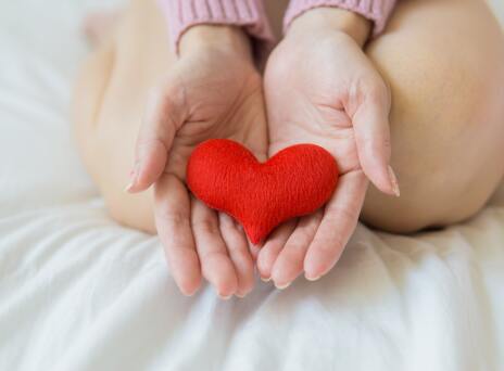 Χέρια που κρατούν υφασμάτινη καρδιά